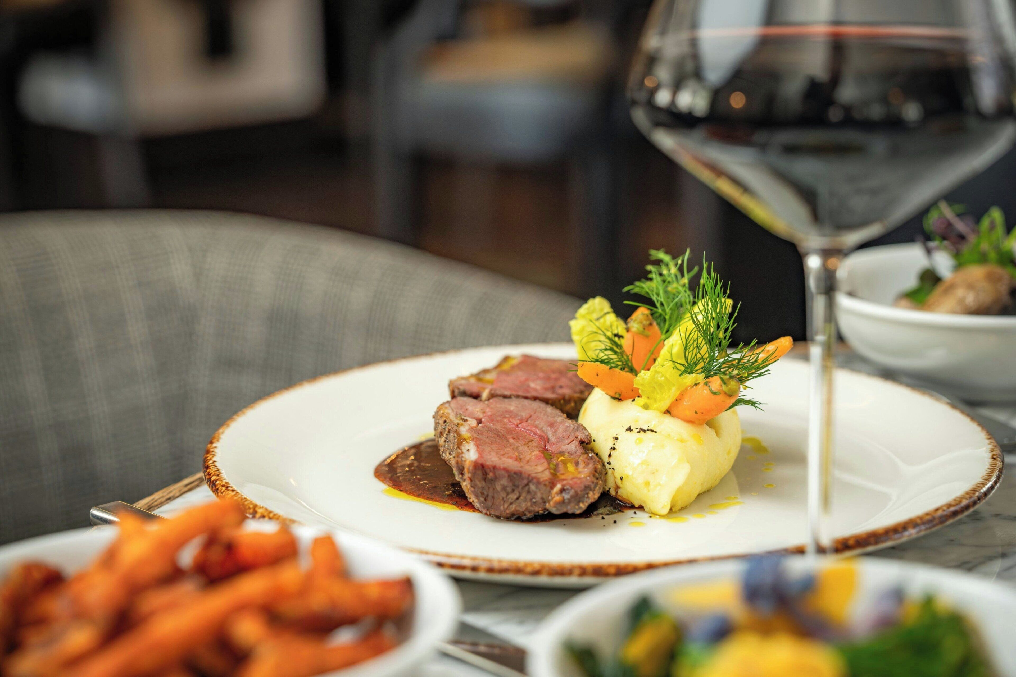 A plate of food with a glass of red wine.