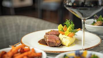 A plate of food with a glass of red wine.