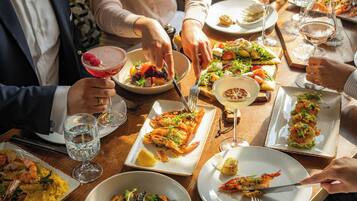 A dining table with various dishes and drinks, including seafood and salads.