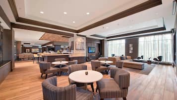 Relax in our inviting lobby with a central seating area, bar, and large window offering a view of the outdoors.