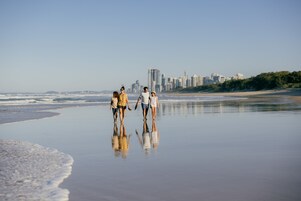 Una playa con un horizonte urbano al fondo.