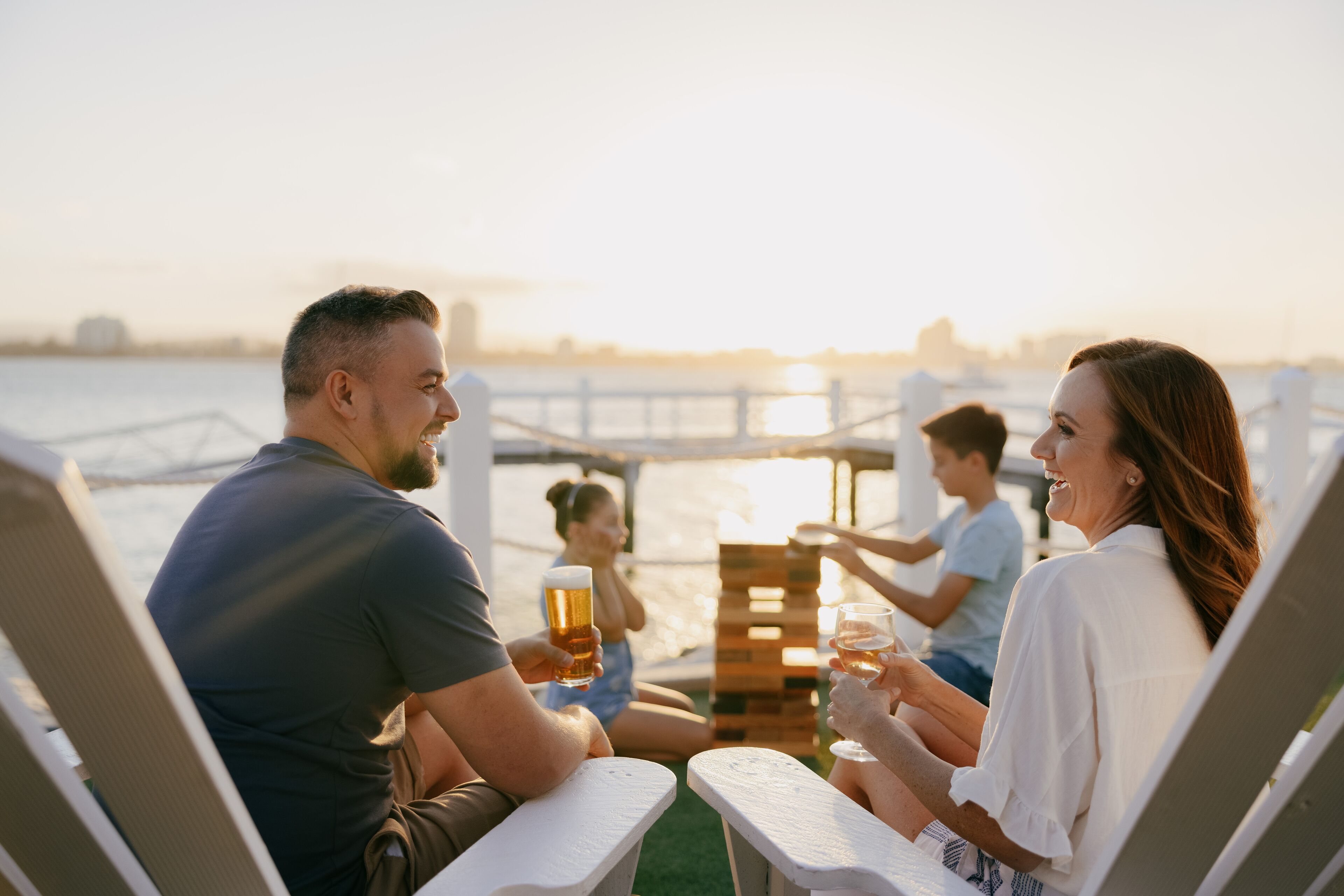 Um grupo de pessoas sentadas à mesa à beira-mar, apreciando bebidas.