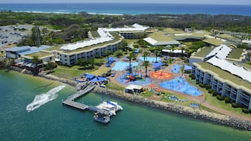 Enjoy the resort's vibrant aquatic park with a large pool and water slides, adjacent to a marina with boats.