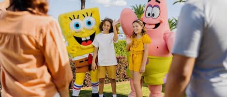 A group of people standing in front of a Spongebob Squarepants and Patrick Star statue.