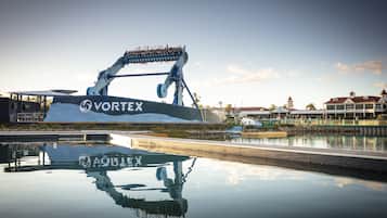 A water ride with a large structure labeled "VORTEX" reflecting on the water surface.