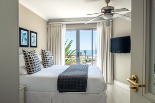 Una habitación de hotel con cama, televisión y vista al mar.