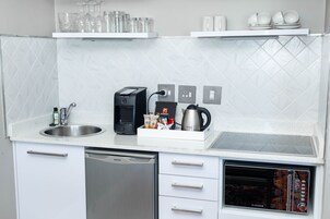 A modern kitchen with a dishwasher, coffee maker, and a microwave.