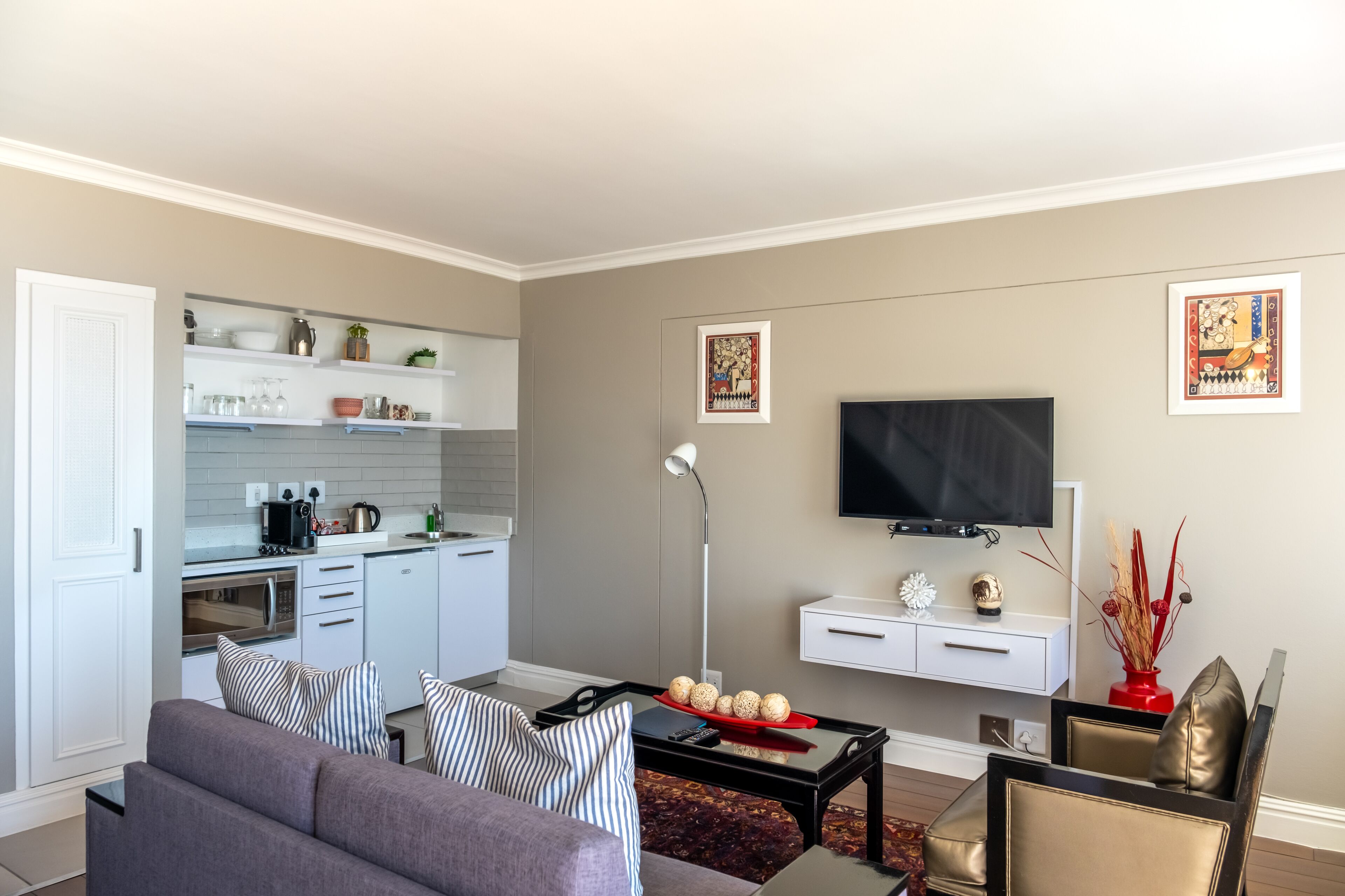 Una sala de estar moderna con un sofá, una mesa de centro y un televisor de pantalla plana montado en la pared.