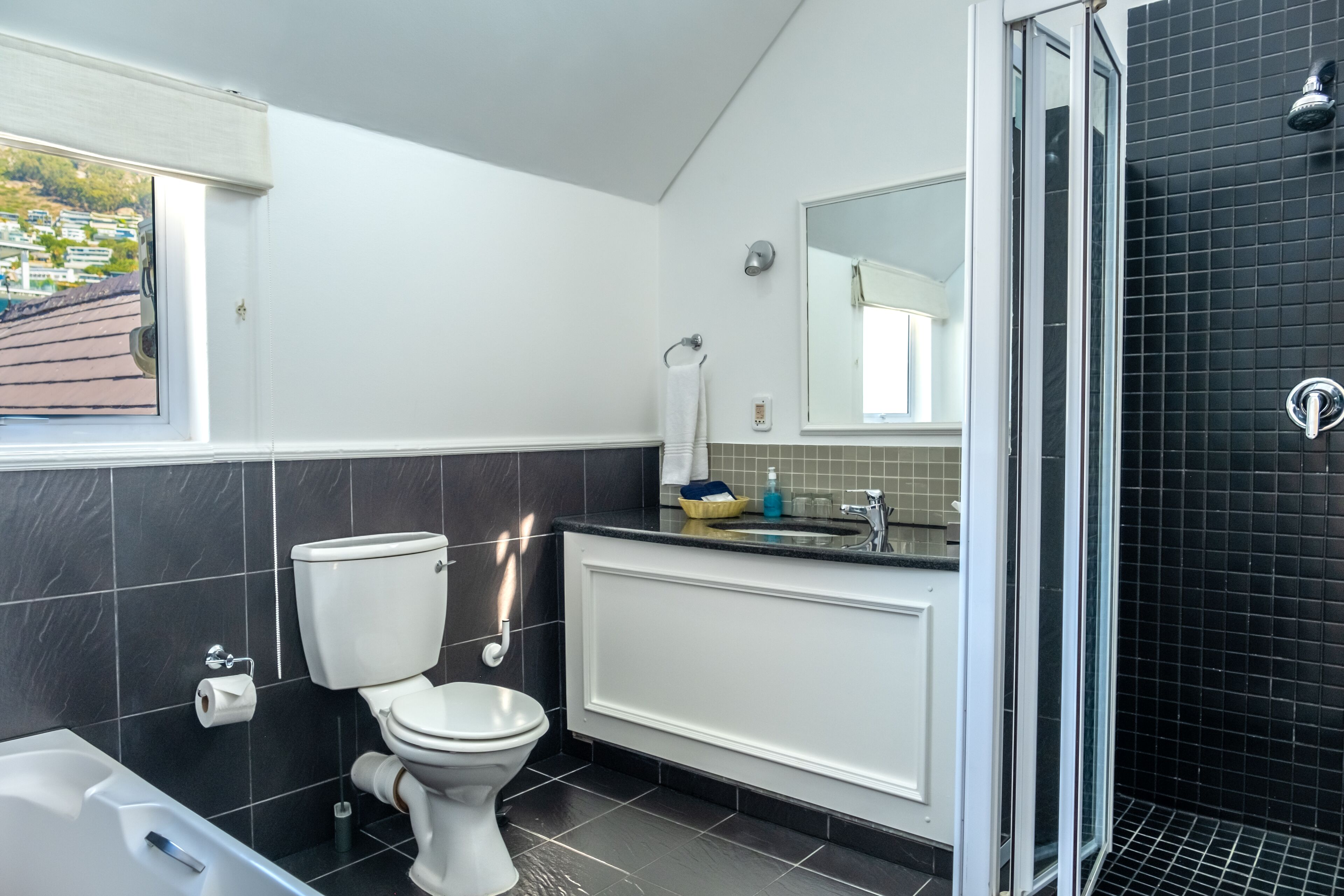 A modern bathroom with a toilet, bathtub, and shower.