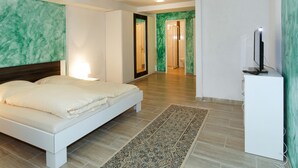 Ett modernt hotellrum med en säng, ett skrivbord och en tv.