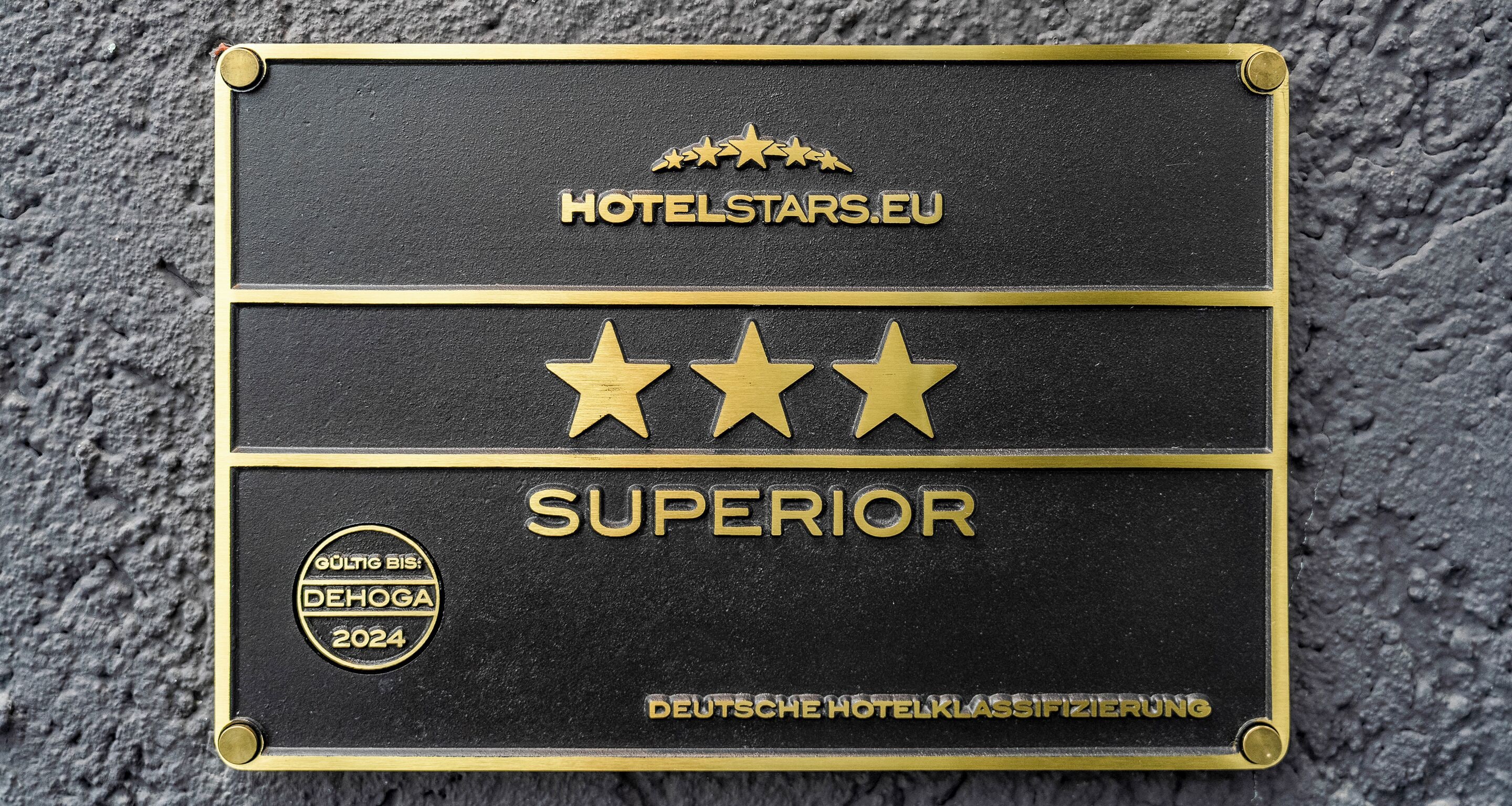 A black plaque with gold lettering and stars, indicating a hotel rating.