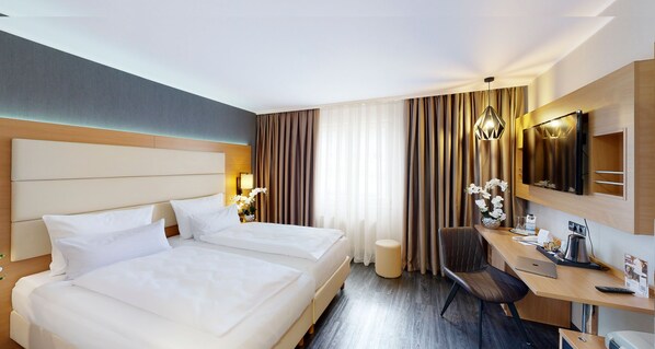 A hotel room with two beds, a desk, a chair, a TV, and a lamp. - PLAZA INN Heilbronn (Heilbronn)