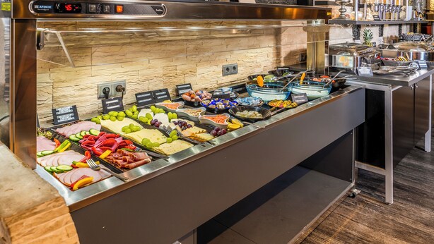 A buffet with various food items including meats, cheeses, and fruits. - PLAZA INN Heilbronn (Heilbronn)