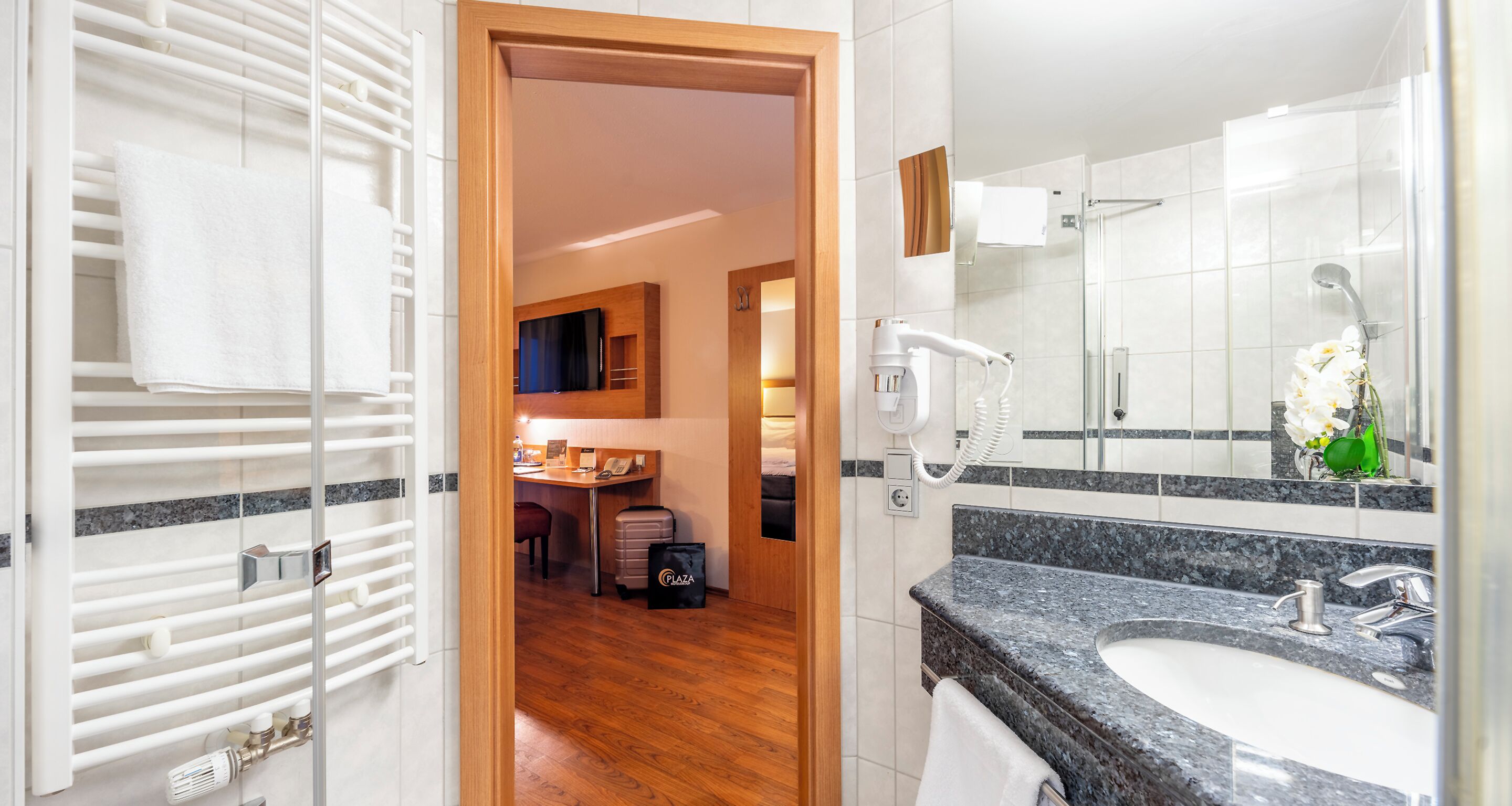 A modern bathroom with a granite countertop, a sink, and a mirror.