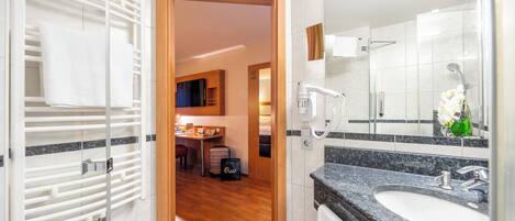 Un baño moderno con encimera de granito, un lavabo y un espejo.