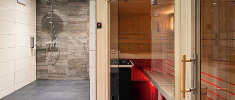 Un baño moderno con ducha, banco y sauna.