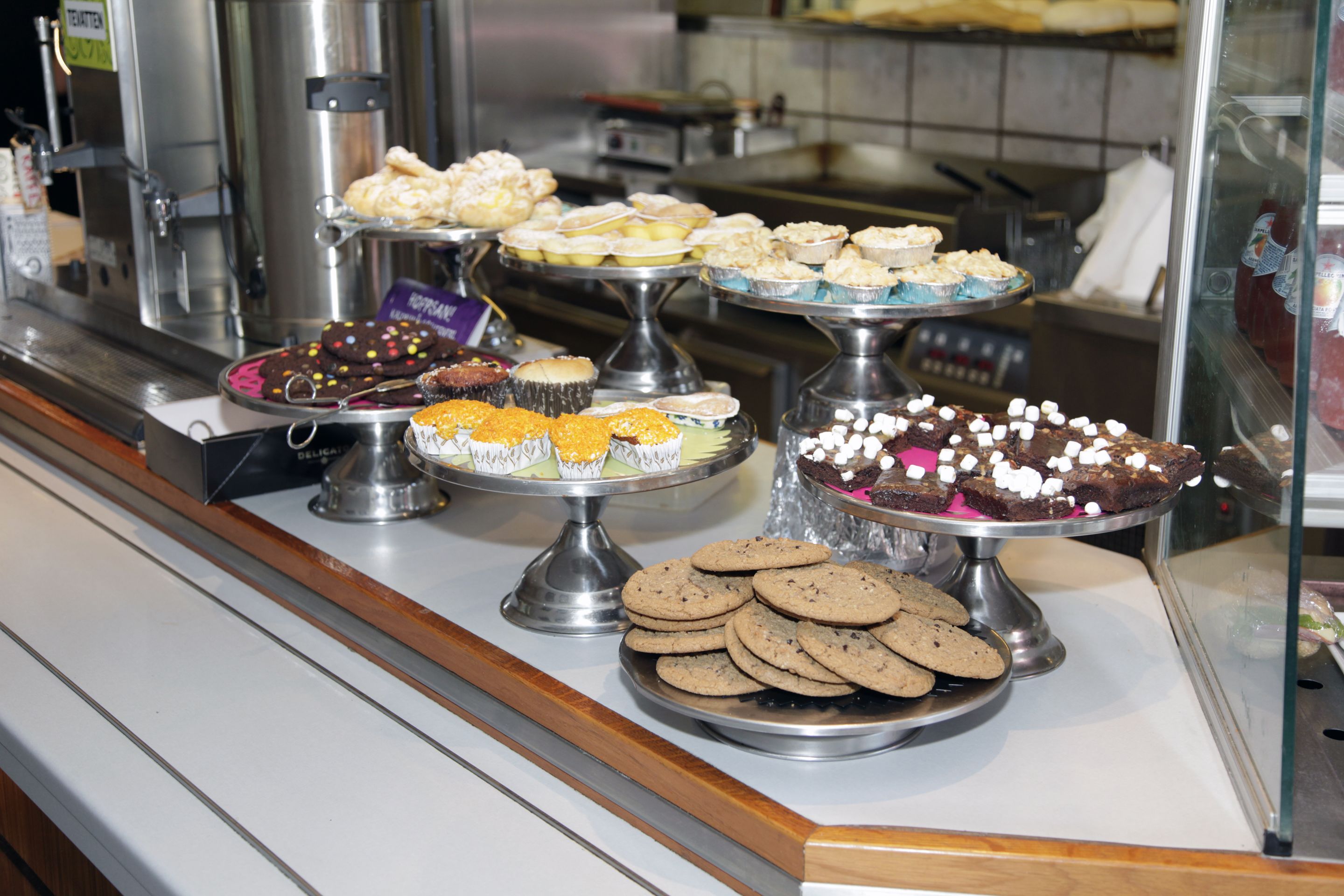 Un bufé con diversos postres, incluyendo galletas, pasteles y repostería.