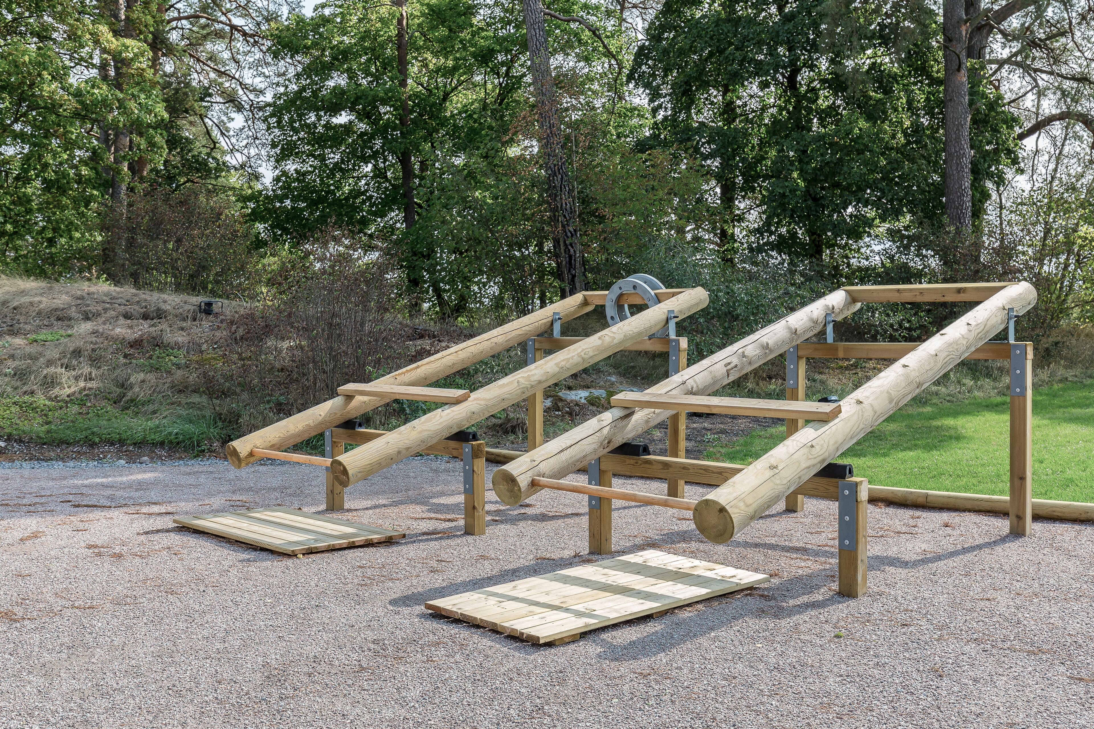 Outdoor wooden climbing structures in a park setting.