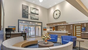 A modern lobby with seating areas, a reception desk, and a large wall clock. - Best Western Plus Pembina Inn & Suites (Winnipeg)