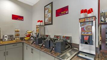 Un espace de service en libre-service où l’on peut se servir du café, équipé de plusieurs machines à café et d’un distributeur à commande par simple pression.
