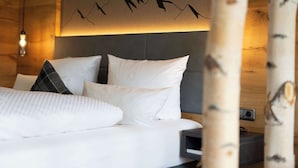 A bed with white bedding and a mountain art piece above it. - Alpenhof Oberstdorf Hotel & Spa, BW Signature Collection (Oberstdorf)