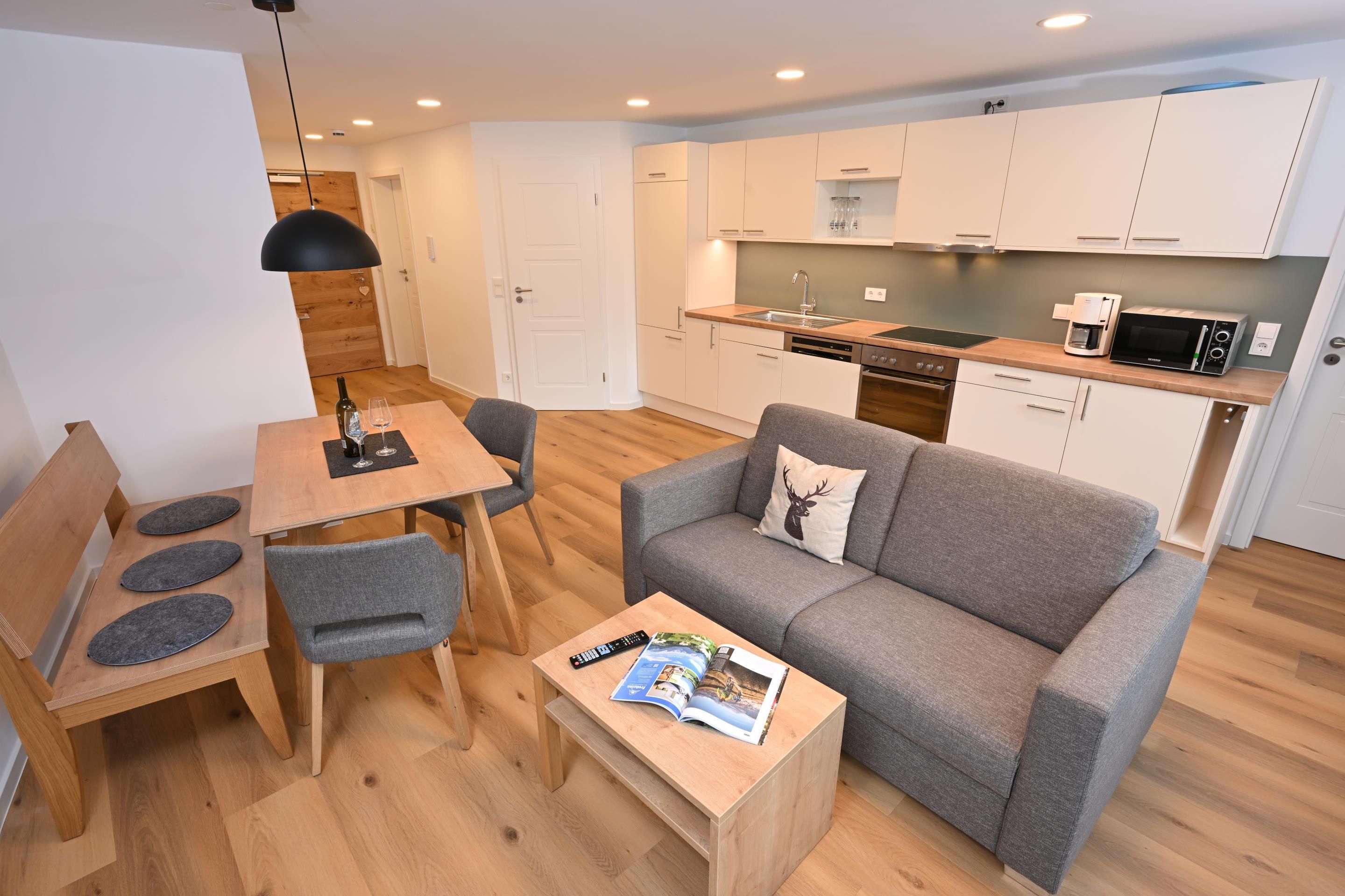 A compact living space with a kitchenette, a dining area, and a seating area.