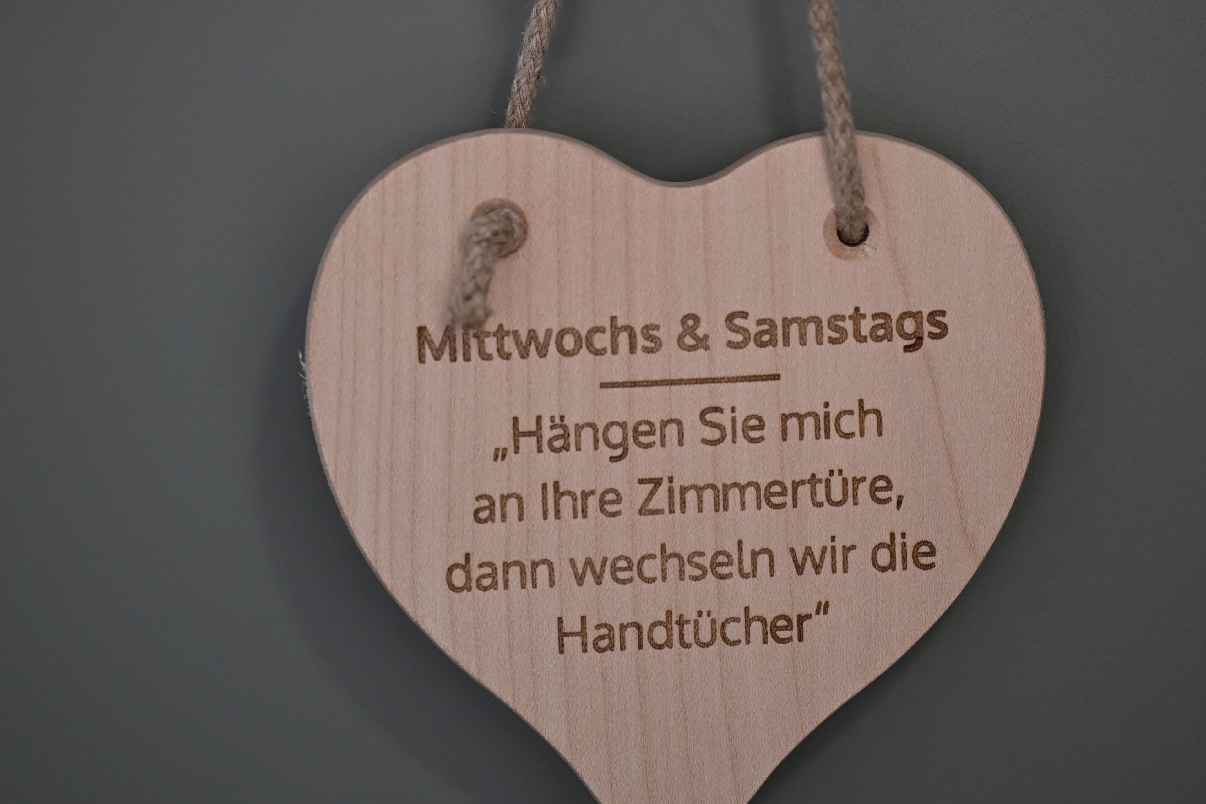 A wooden heart-shaped sign with text.