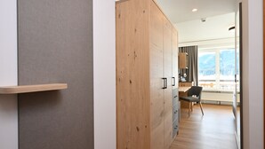 A modern kitchen with wooden cabinets, a built-in stove, and a view of the outdoors. - Alpenhof Oberstdorf Hotel & Spa, BW Signature Collection (Oberstdorf)