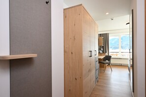 A modern kitchen with wooden cabinets, a built-in stove, and a view of the outdoors. - Alpenhof Oberstdorf Hotel & Spa, BW Signature Collection (Oberstdorf)