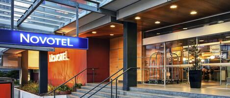 L’extérieur de l’hôtel Novotel se distingue par une enseigne bien visible, un escalier et une entrée en verre.