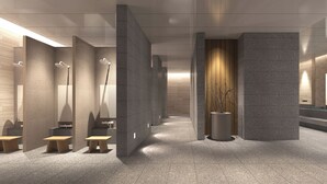 Un baño moderno con varias zonas de ducha, bancos y una columna central con una planta.
