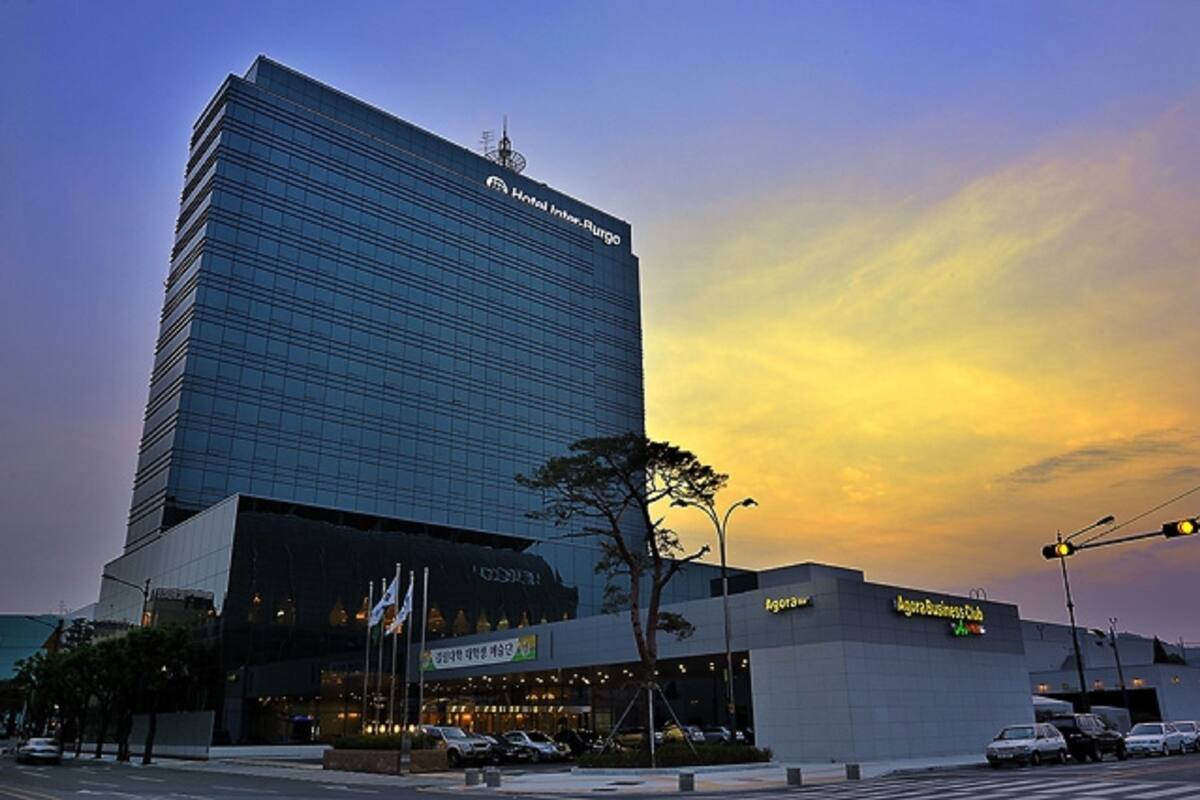 A modern hotel with a glass facade and a sign for 'Hotel Inter-Rugio'.