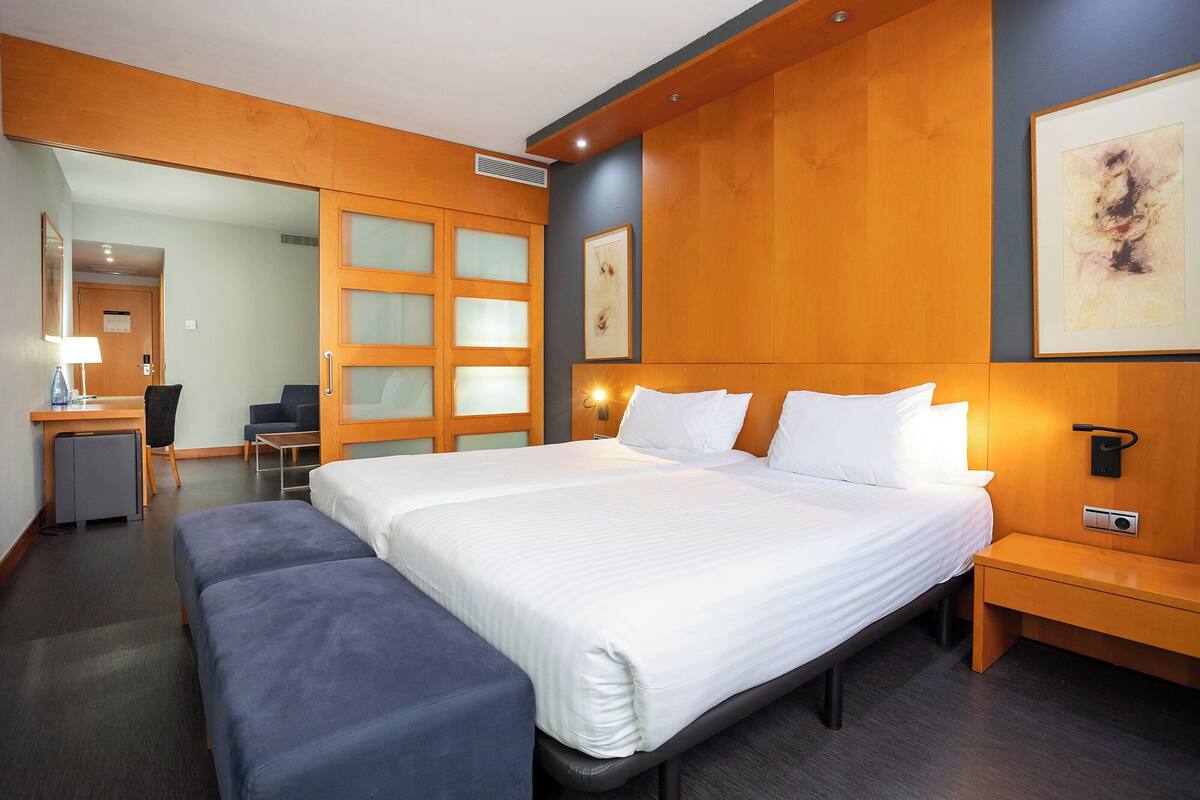 Een hotelkamer met een groot bed, een bureau, een stoel en een bank.