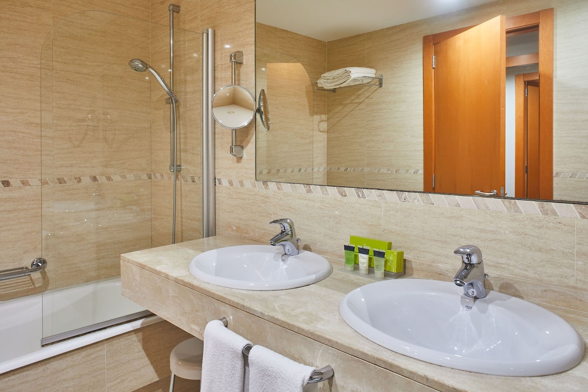 junior suite (silken club) | bathroom | bathtub, designer toiletries, hair dryer, bidet