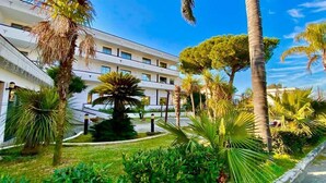 A modern hotel with a central courtyard, surrounded by palm trees and well-maintained greenery. - Hotel Clorinda (Capaccio-Paestum)