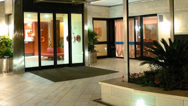 A hotel entrance with a glass door, a reception desk, and potted plants. - Hotel Duca degli Abruzzi (Montesilvano)