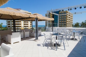 A rooftop terrace with outdoor seating and a view of the sea. - Hotel Duca degli Abruzzi (Montesilvano)
