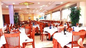 A spacious restaurant with multiple tables and chairs, large windows, and a ceiling with recessed lighting. - Hotel Duca degli Abruzzi (Montesilvano)