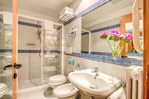 Enjoy a refreshing shower in the bathroom with a glass-enclosed shower, double sink vanity, and large mirror.