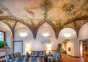 Experience the grandeur of this luxurious space, featuring a high ceiling with intricate frescoes and a stunning chandelier.