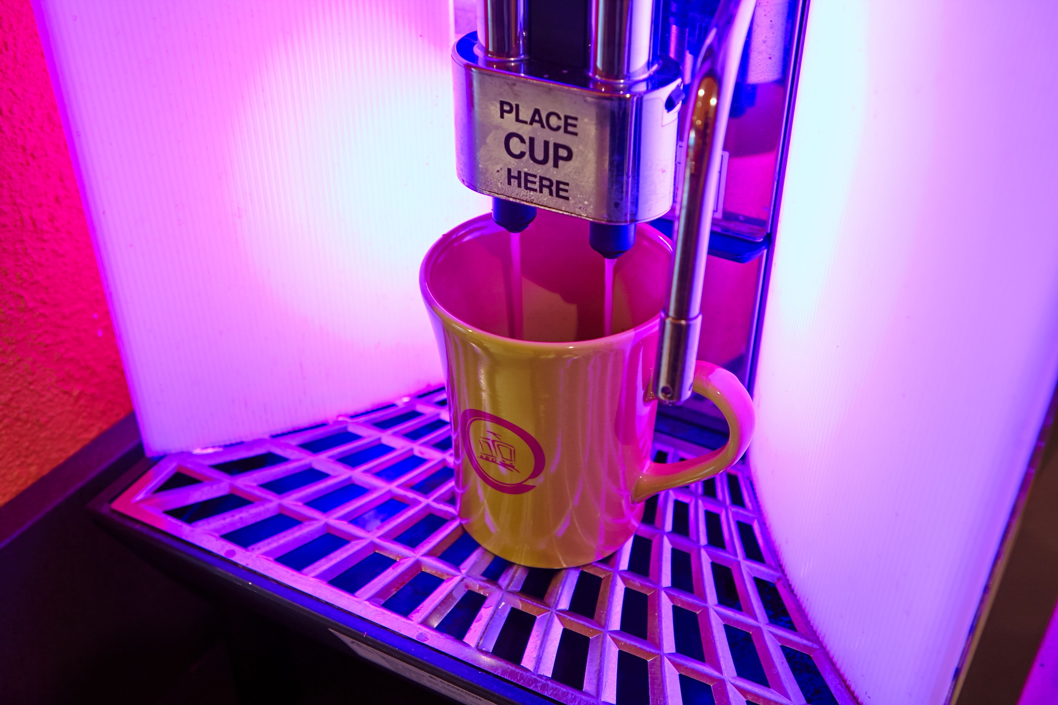 Una máquina de café con un letrero que indica colocar una taza.