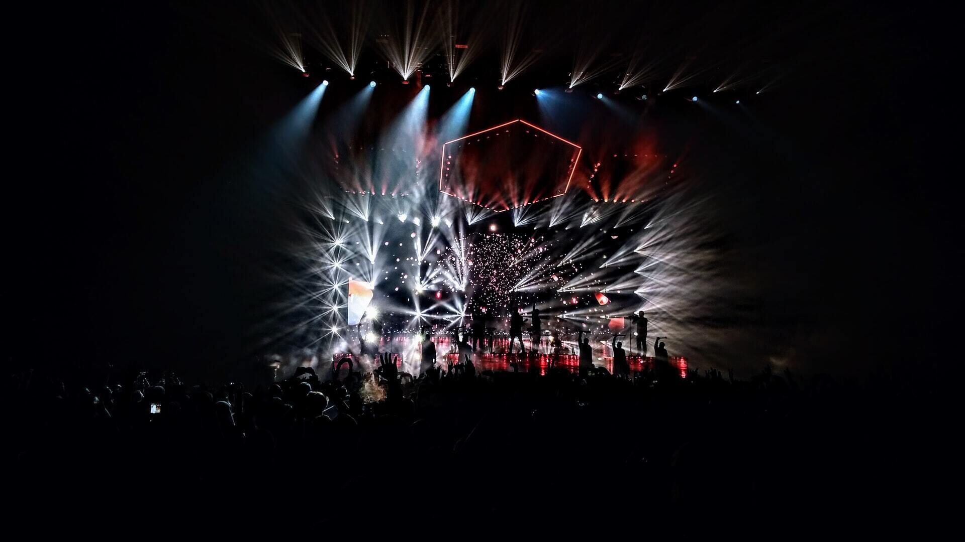A concert with stage lighting and a crowd.