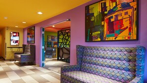 Un interior moderno con un sofá estampado, un televisor y arte abstracto en la pared.