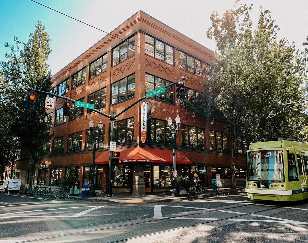 A multi-story building with large windows and a red awning.