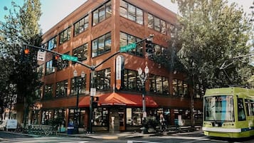 A multi-story building with large windows and a red awning.