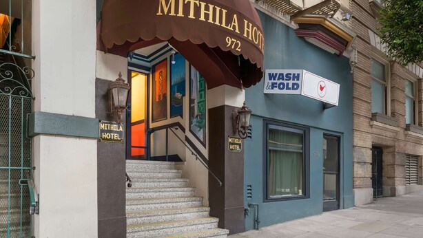 The exterior of the Mithila Hotel with a brown awning, a staircase leading to the entrance, and a 'Wash Fold' sign. - Mithila San Francisco, SureStay Collection by Best Western (San Francisco)