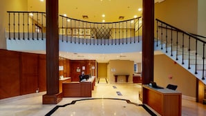 A spacious lobby with a marble floor, a reception desk, and a staircase leading to an upper level. - Estanplaza Paulista (São Paulo)