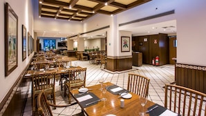 A spacious restaurant with wooden tables and chairs, a tiled floor, and a high ceiling with exposed beams. - Estanplaza Paulista (São Paulo)