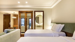 A hotel room with a bed, a chair, a desk, and a view of the city. - Estanplaza Paulista (São Paulo)