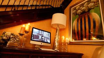 A staircase with a decorative metal railing, a desk with a computer monitor, a lamp, and a chair.